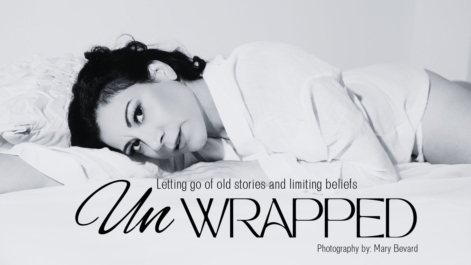 black and white photo of an old hollywood style woman in black hair laying down facing the camera with a sensual inviting expression on her face