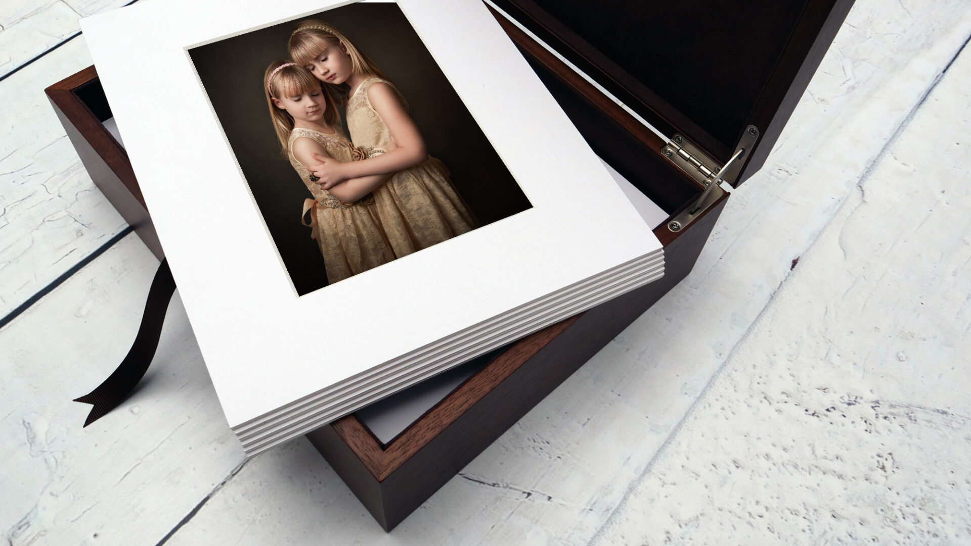 two young sisters holding each other in prayer displayed in a folio box