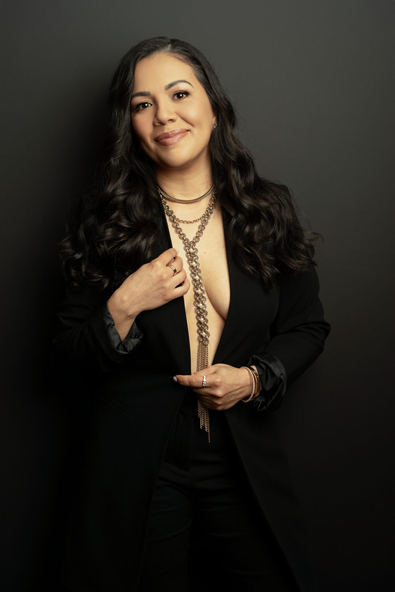 a woman wearing a black suit and necklace