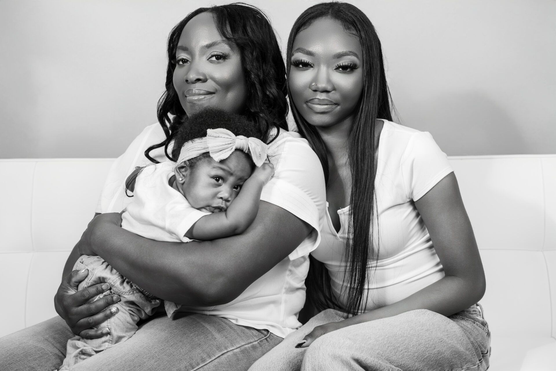 Three women with a baby together in a long island photo studio.