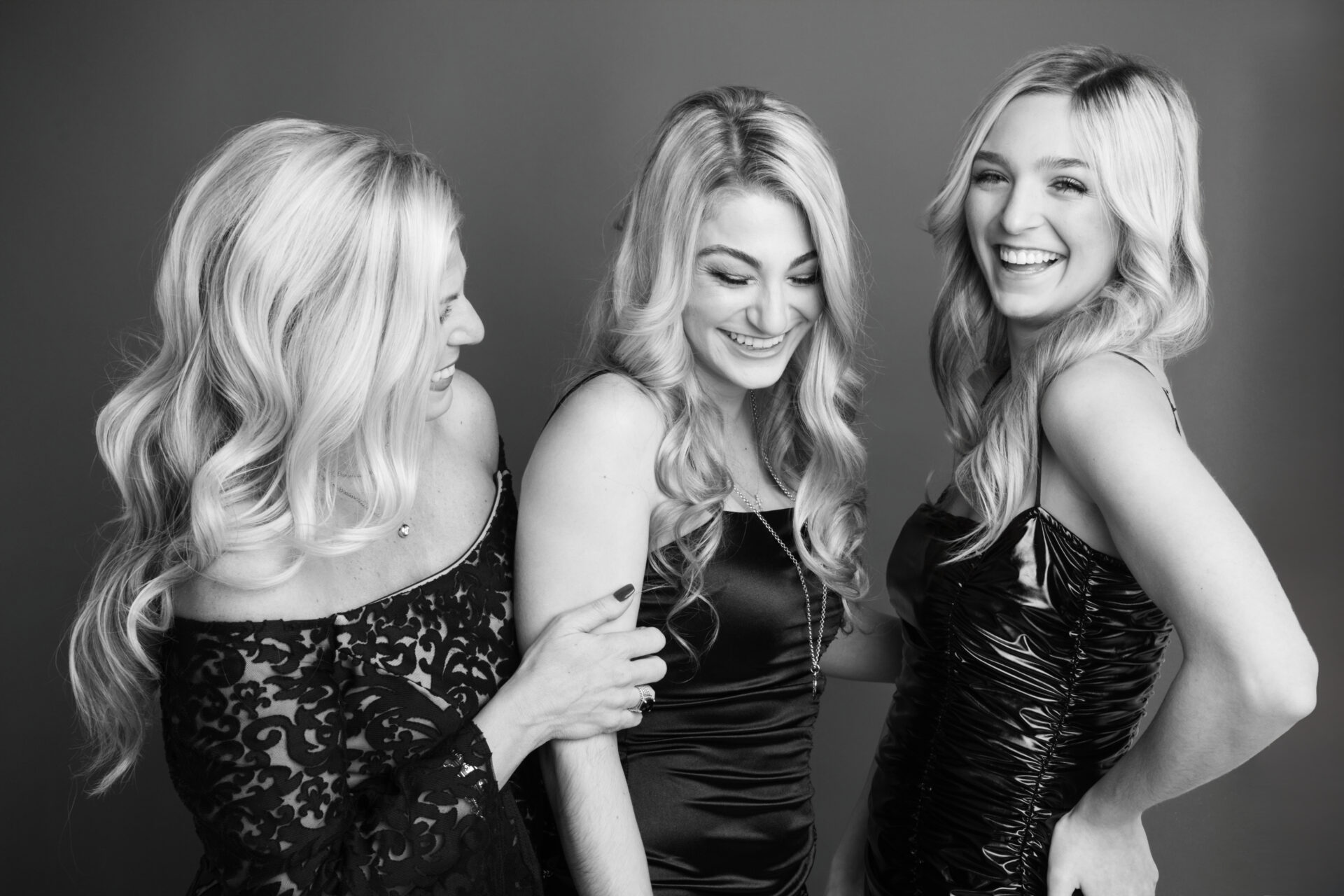 candid black and white of mother and daughters laughing expressing joy in a long island studio