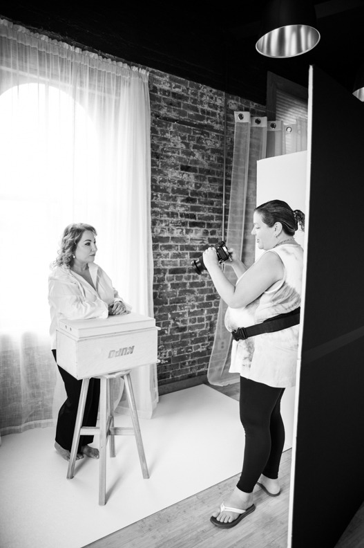 Behind-the-scenes moment of photographer capturing a professional branding portrait for a Long Island business owner in a natural light studio