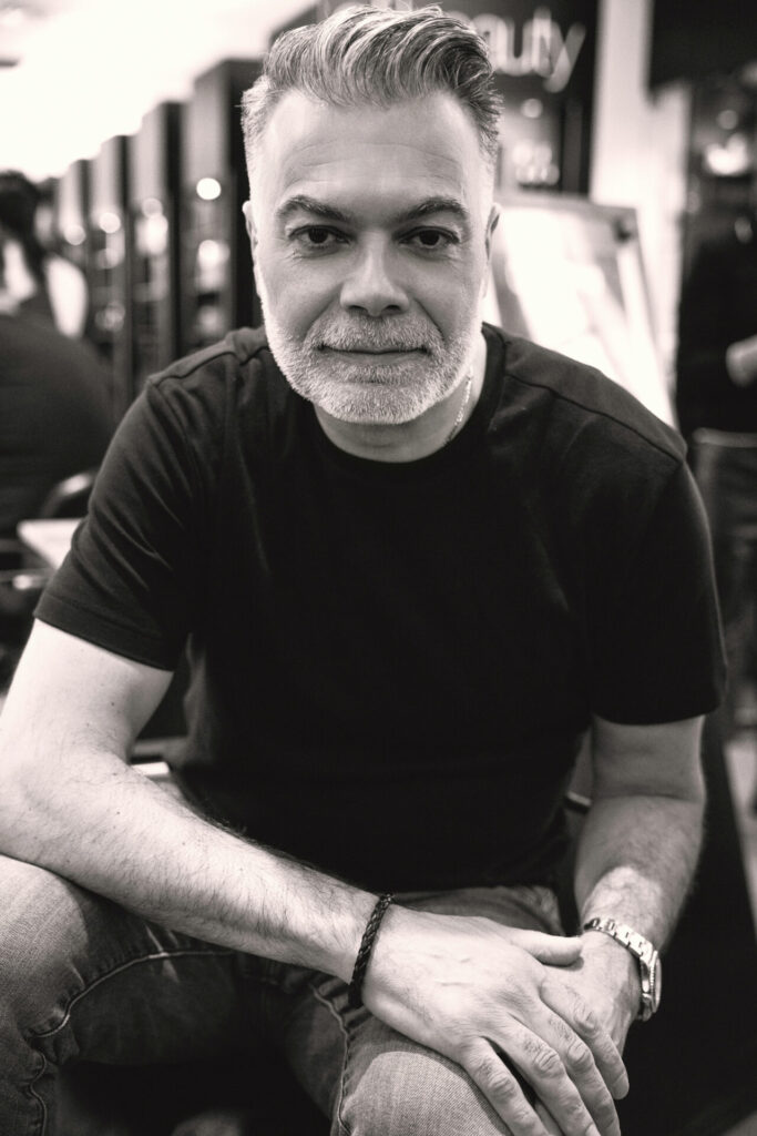 Black and white personal branding portrait of a man sitting confidently in The BeVard Studio in Farmingdale, New York