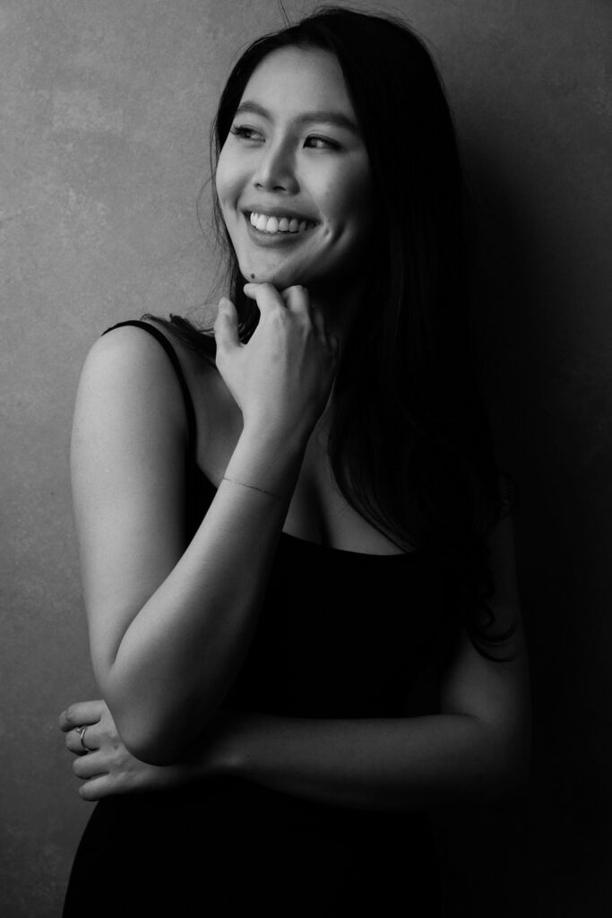 Black and white portrait of a woman smiling in soft studio lighting, photographed by The BeVard Studio in Long Island