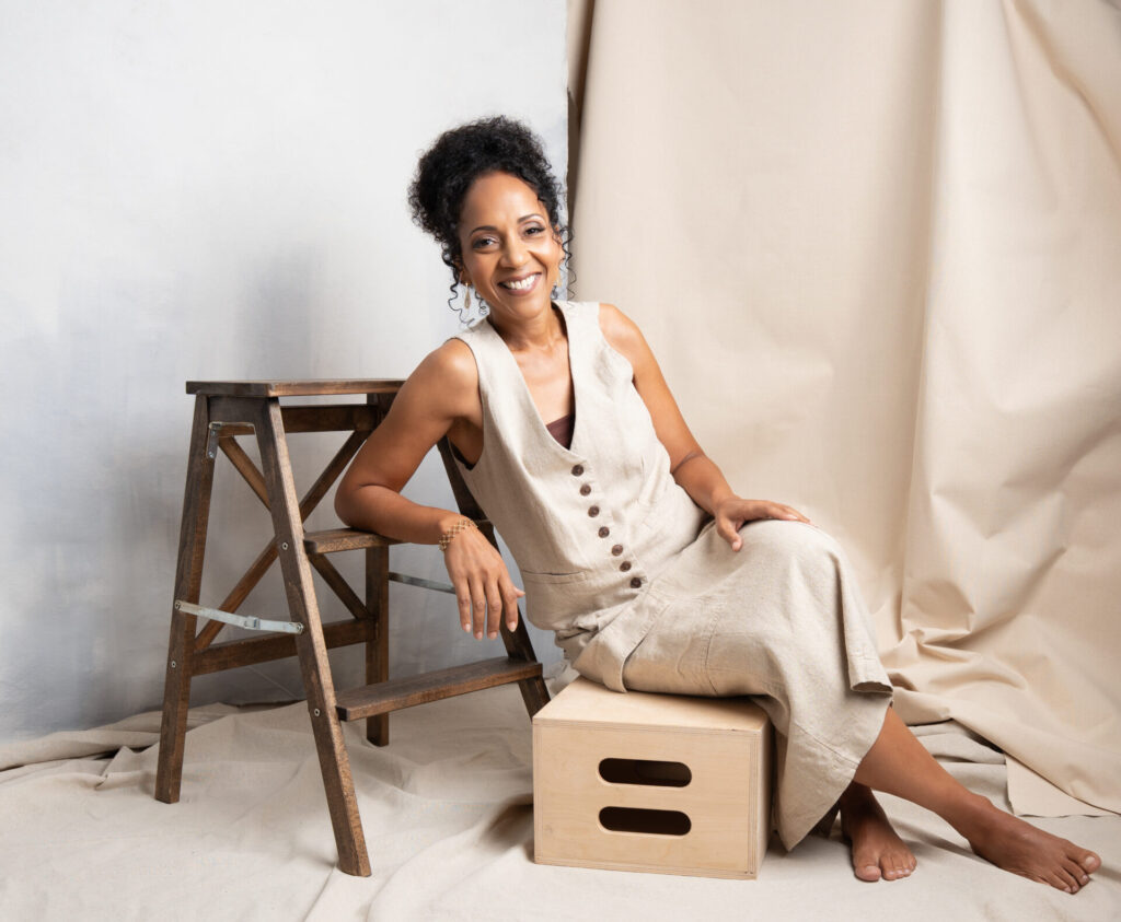 Lifestyle personal branding portrait of a woman in a natural linen outfit sitting on a wooden box, photographed at The BeVard Studio on Long Island, New York