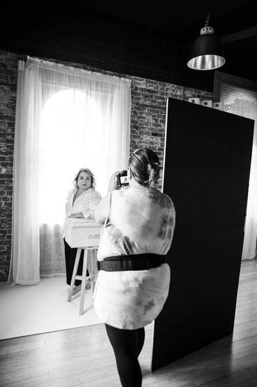 Personal branding photographer adjusting studio lighting for a client in Farmingdale New York