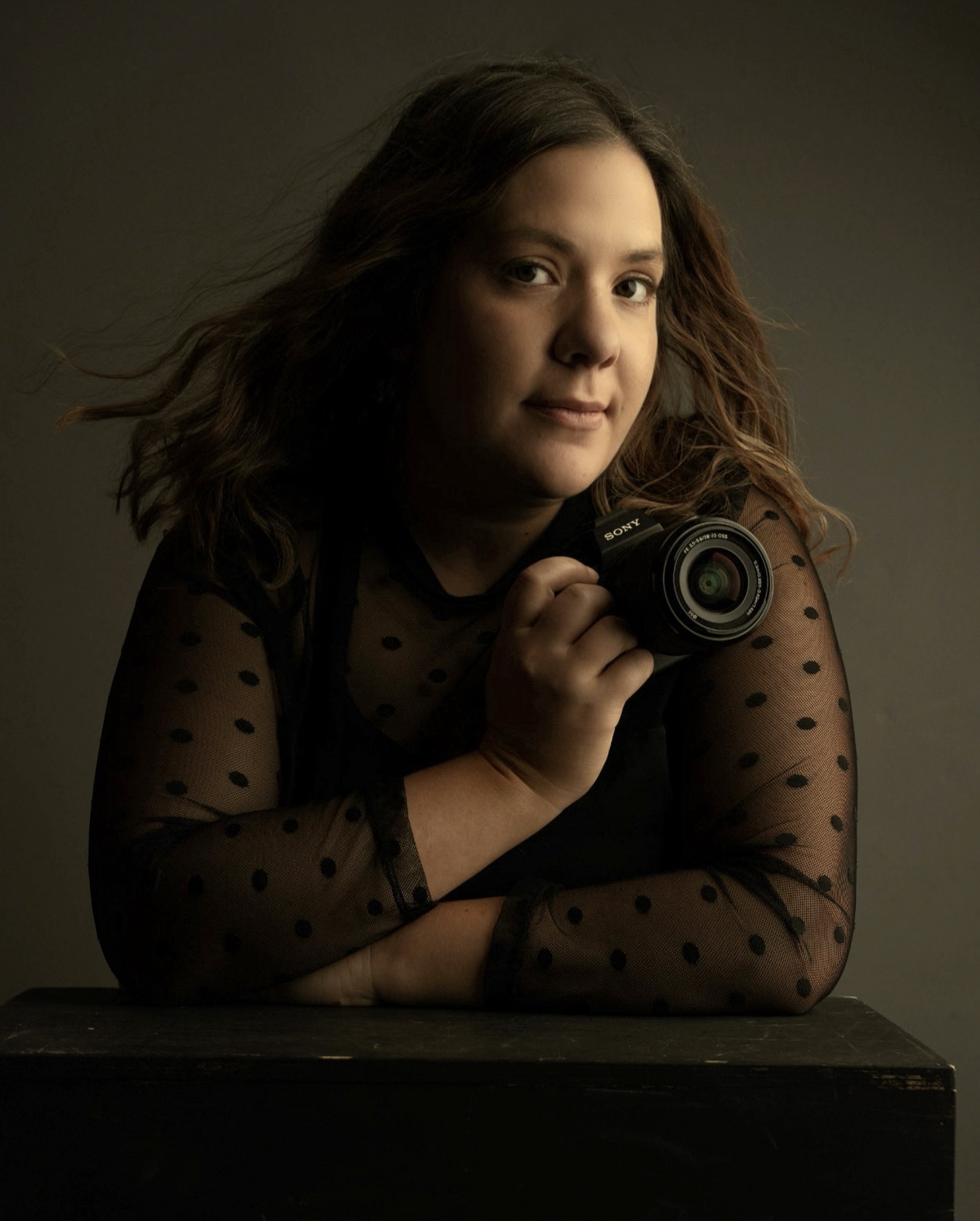 Long Island photographer posing with her camera in her South Farmingdale Studio