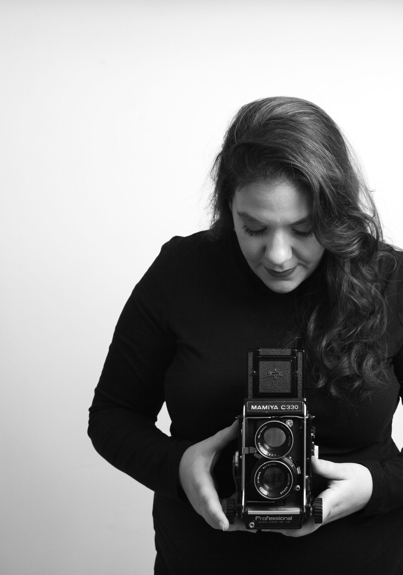 Long island personal branding and headshot photographer smiling down at her camera in her Farmingdale studio