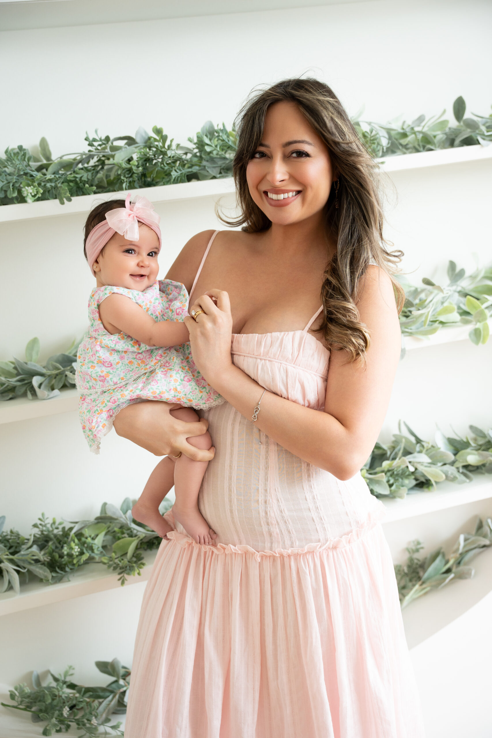 Mother holding her baby daughter in a pink dress, multi-generational family photoshoot Long Island