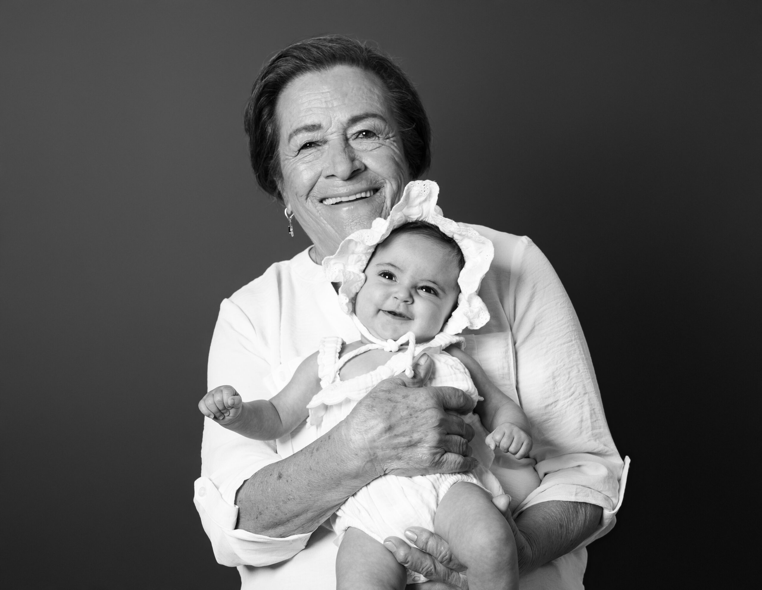 Black and white portrait of a great-grandmother holding the baby, five-generation photoshoot