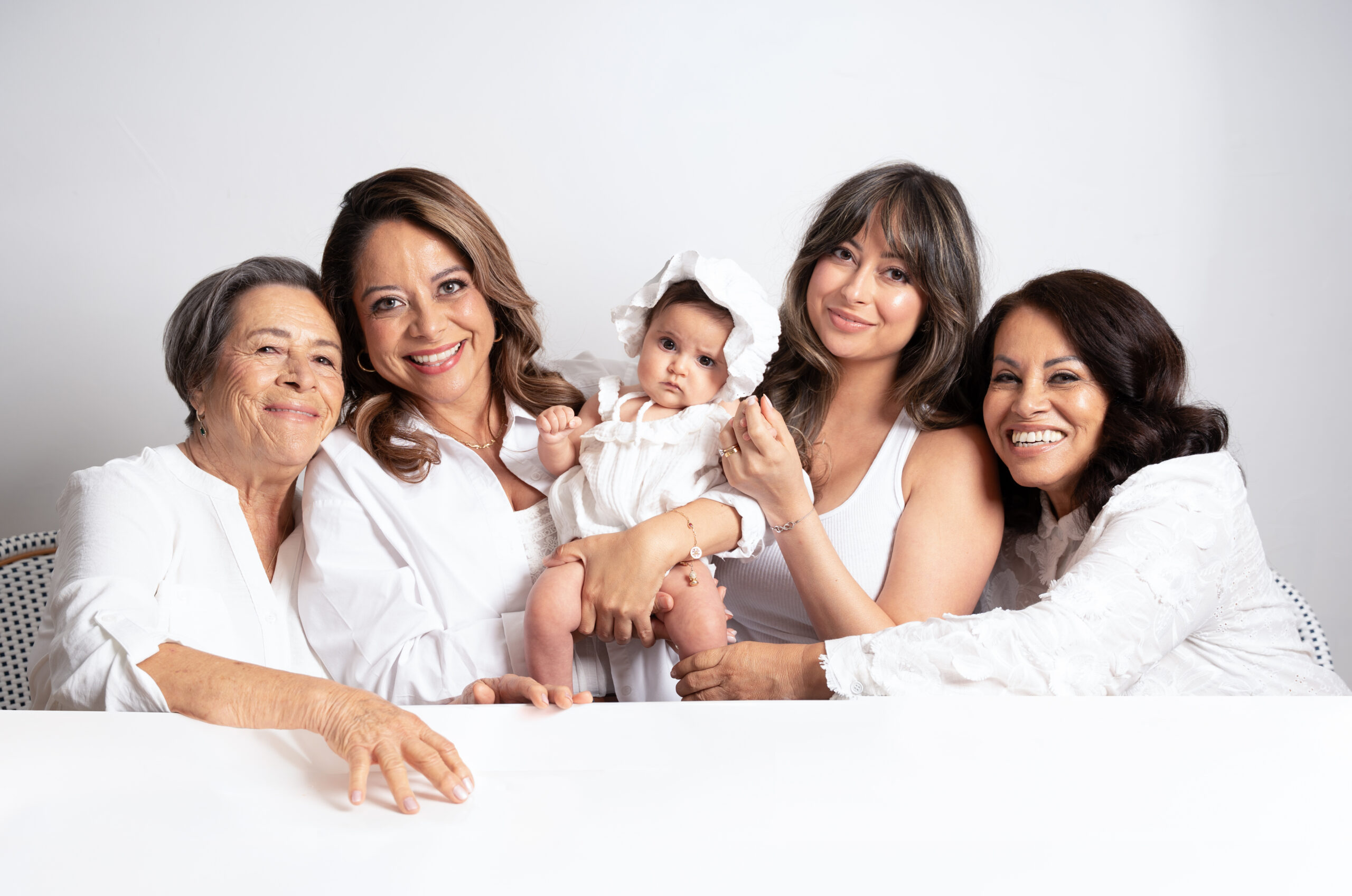 Five generations of women with a baby in white on a studio set, Long Island family photography